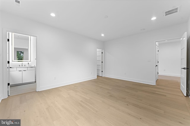 spare room featuring sink and light wood-type flooring