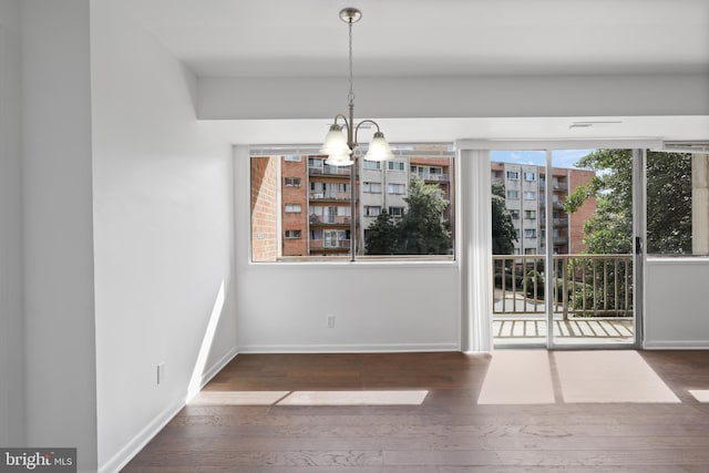 unfurnished dining area with a chandelier and dark wood-type flooring