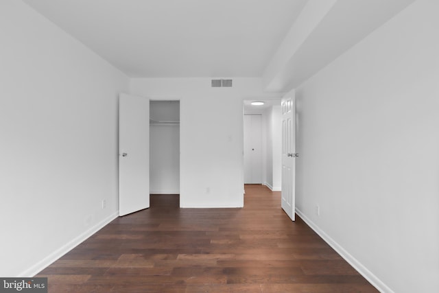 unfurnished bedroom with a closet and dark hardwood / wood-style flooring