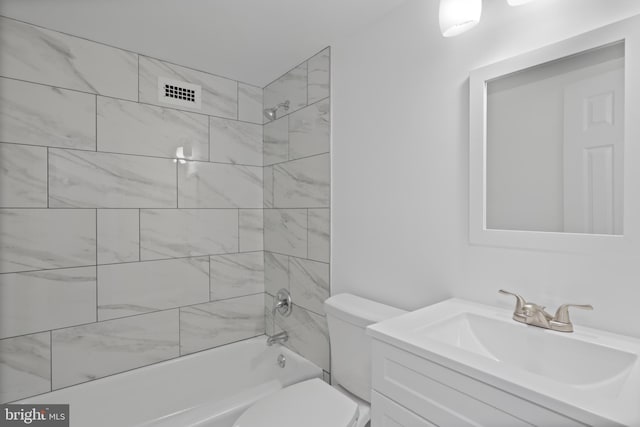 full bathroom featuring vanity, toilet, and tiled shower / bath combo