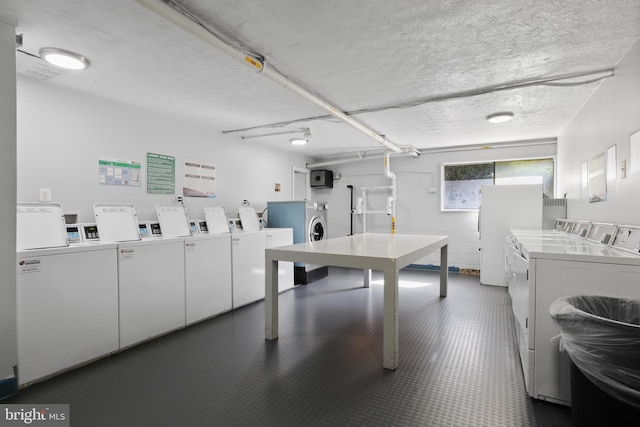 washroom with washer and dryer and a textured ceiling