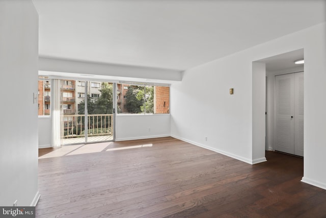 unfurnished room with dark hardwood / wood-style flooring