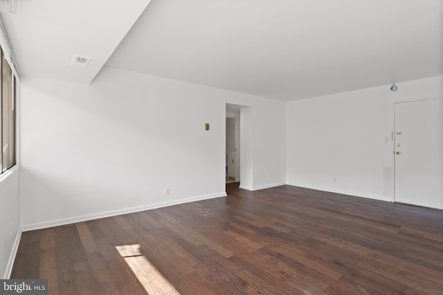 unfurnished room with dark wood-type flooring