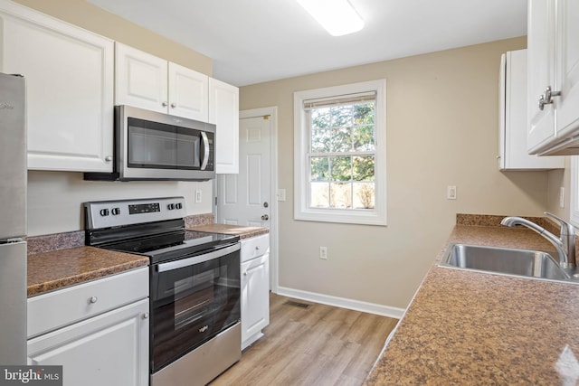 kitchen featuring light hardwood / wood-style flooring, stainless steel appliances, sink, and white cabinets