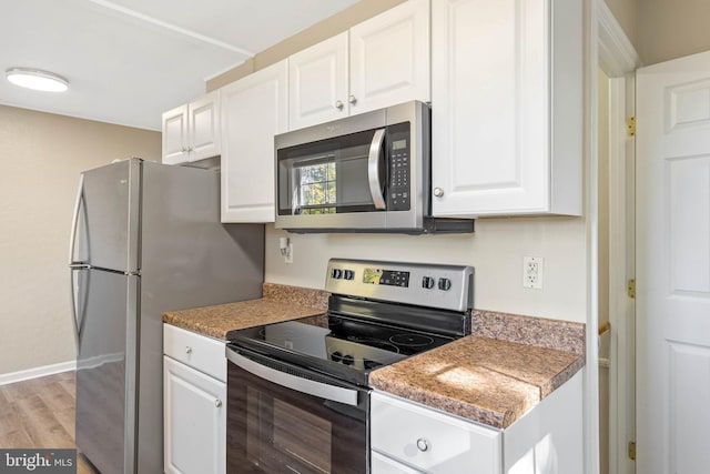 kitchen featuring appliances with stainless steel finishes, white cabinetry, and light hardwood / wood-style floors