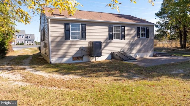 back of house with a yard and central AC unit