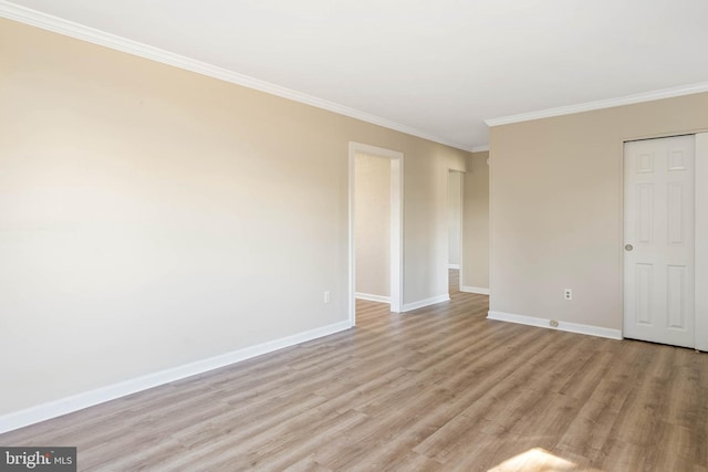 empty room with ornamental molding and light hardwood / wood-style flooring