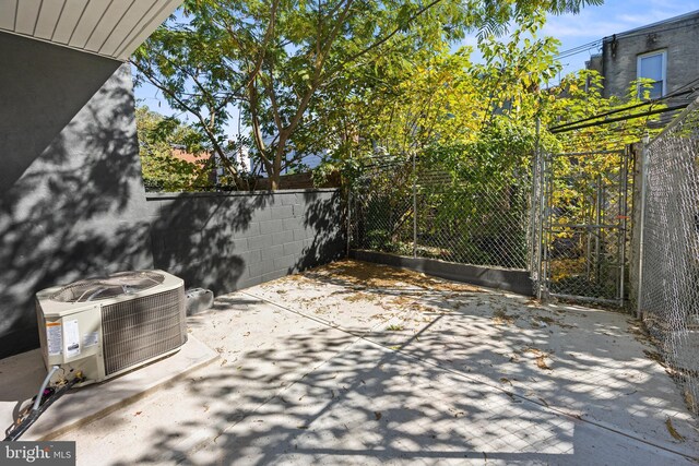 view of patio / terrace with fence, a gate, and central AC unit