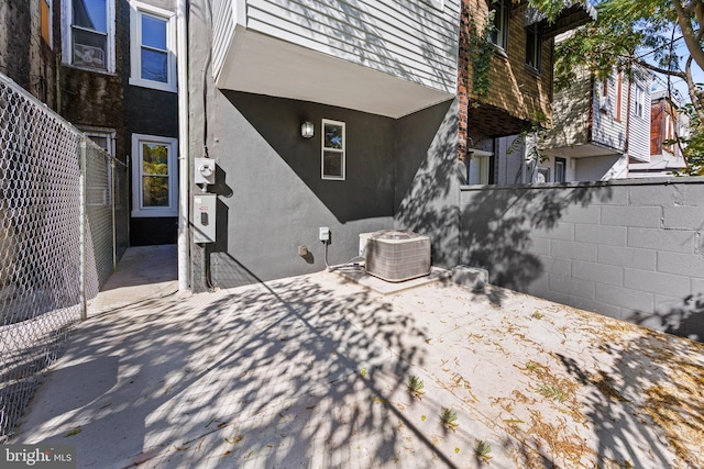 rear view of house featuring central air condition unit, fence, a patio area, and stucco siding