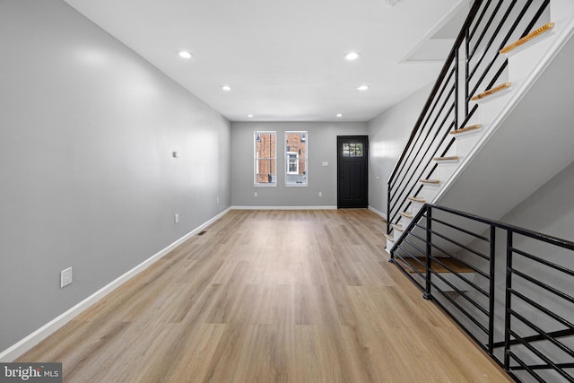 entrance foyer featuring light wood-style flooring, baseboards, recessed lighting, and stairway