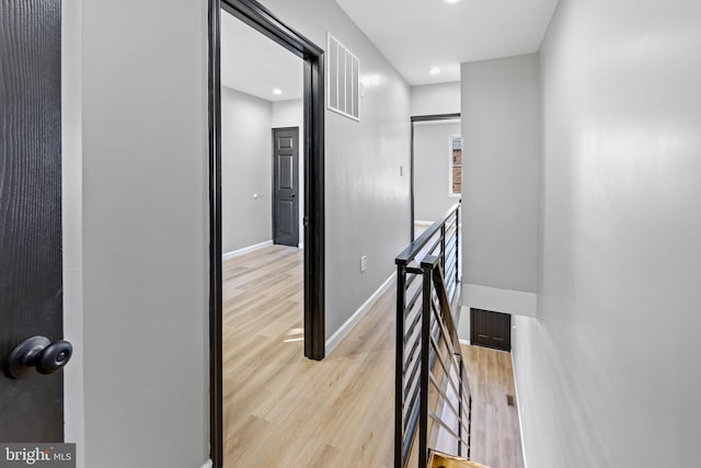 hall featuring recessed lighting, an upstairs landing, visible vents, and light wood-type flooring