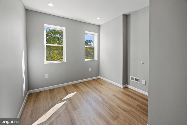 unfurnished room featuring baseboards, wood finished floors, visible vents, and recessed lighting