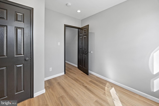 unfurnished bedroom featuring light wood-type flooring and baseboards