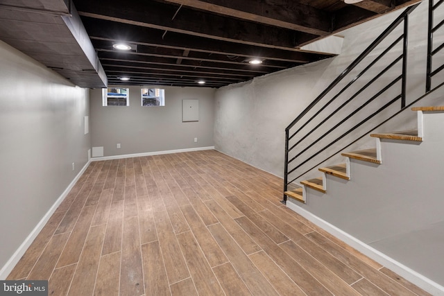 basement with hardwood / wood-style flooring and electric panel