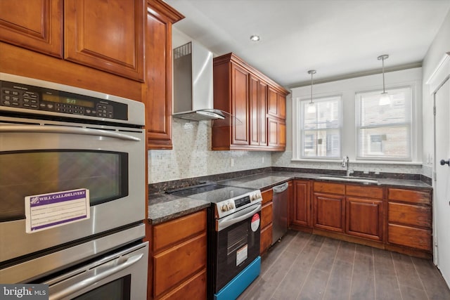 kitchen with wall chimney exhaust hood, stainless steel appliances, sink, pendant lighting, and dark hardwood / wood-style flooring