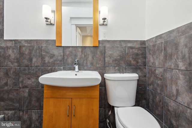 bathroom with tile walls, vanity, and toilet