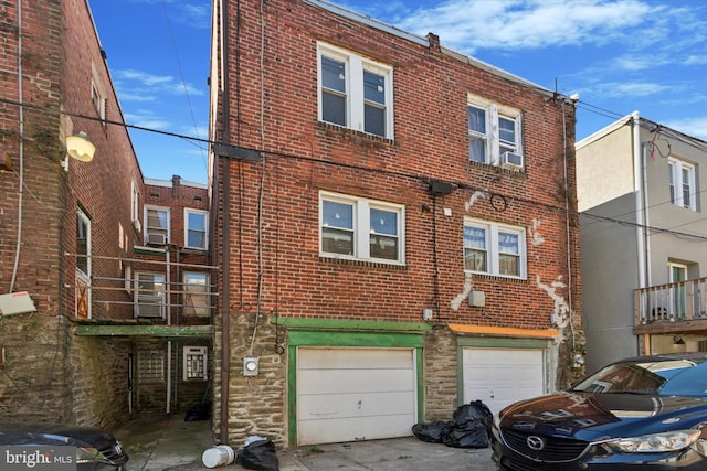 view of property featuring cooling unit, a garage, and a balcony