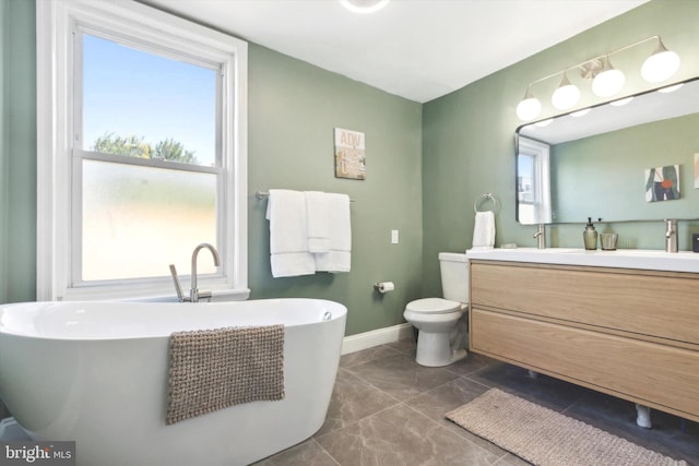 bathroom featuring a wealth of natural light, vanity, a bathtub, and toilet