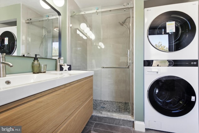 interior space with vanity, stacked washing maching and dryer, and a shower with door