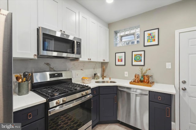 kitchen featuring sink, white cabinetry, stainless steel appliances, and tasteful backsplash