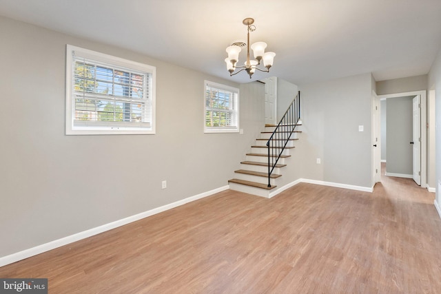 interior space with light hardwood / wood-style floors and a notable chandelier