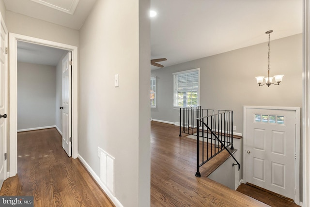 corridor featuring a notable chandelier and dark hardwood / wood-style flooring