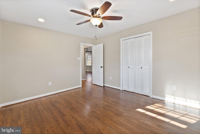 unfurnished bedroom with dark hardwood / wood-style floors, a closet, and ceiling fan