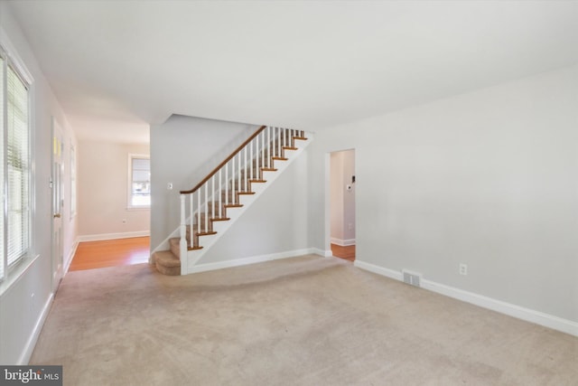 carpeted spare room featuring a healthy amount of sunlight