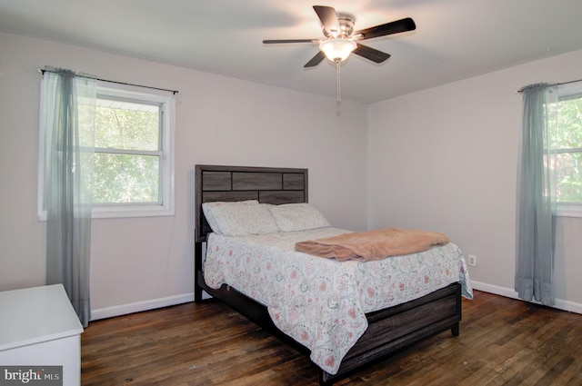 bedroom with dark hardwood / wood-style flooring, multiple windows, and ceiling fan