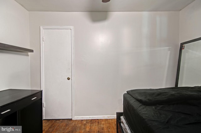 bedroom with dark wood-type flooring