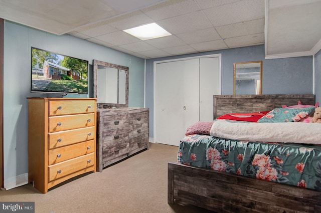 bedroom with a drop ceiling and carpet floors