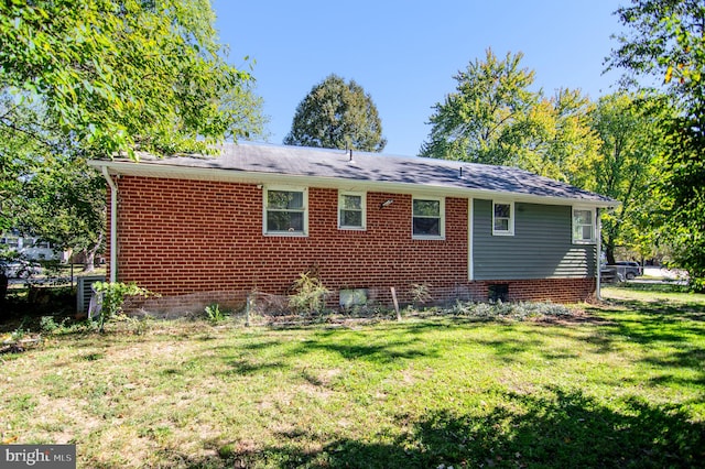 rear view of property featuring a lawn