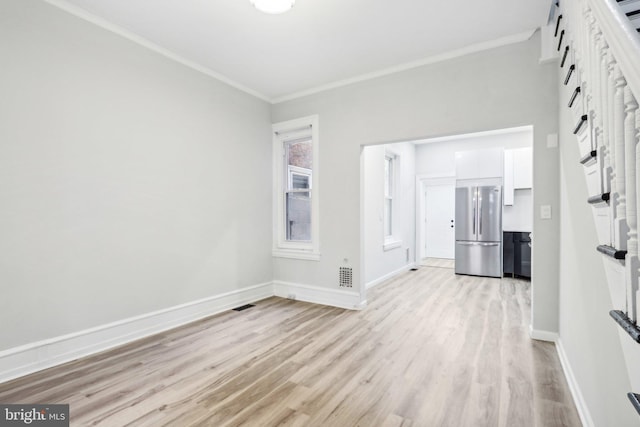 interior space featuring ornamental molding and light wood-type flooring