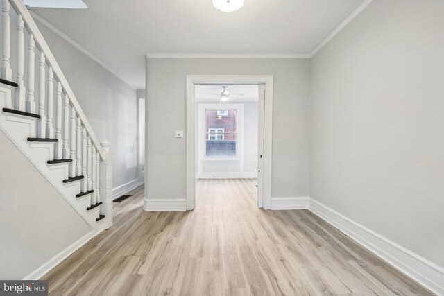 foyer with ornamental molding and light hardwood / wood-style floors