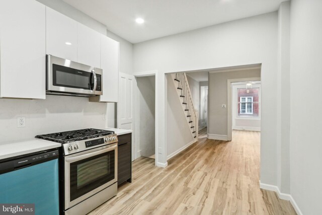 kitchen with white cabinetry, light hardwood / wood-style floors, and stainless steel appliances