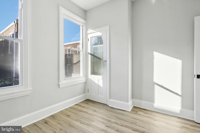 spare room featuring light hardwood / wood-style flooring and a healthy amount of sunlight