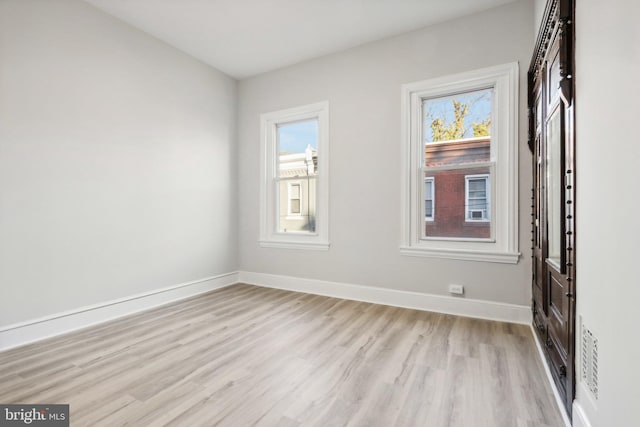 spare room with a wealth of natural light and light hardwood / wood-style floors