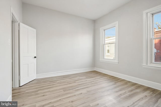 empty room with a healthy amount of sunlight and light hardwood / wood-style flooring