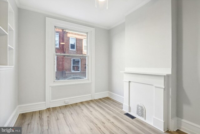 spare room with light hardwood / wood-style flooring and crown molding