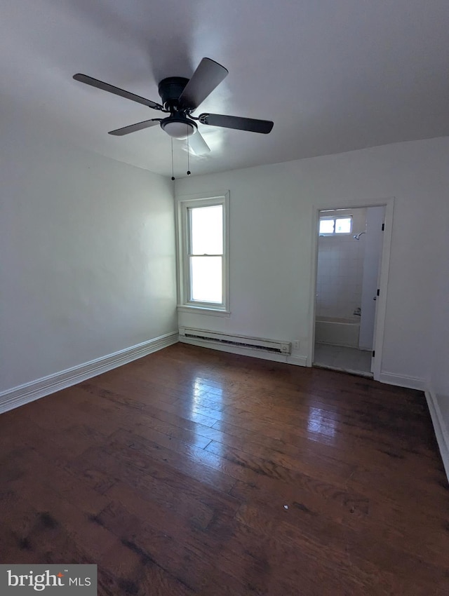 empty room featuring ceiling fan, a baseboard heating unit, and dark wood-type flooring