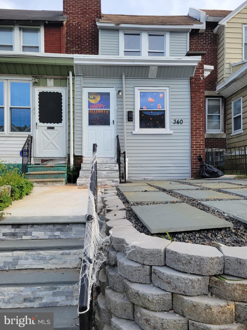 view of front of house featuring entry steps, brick siding, and a chimney