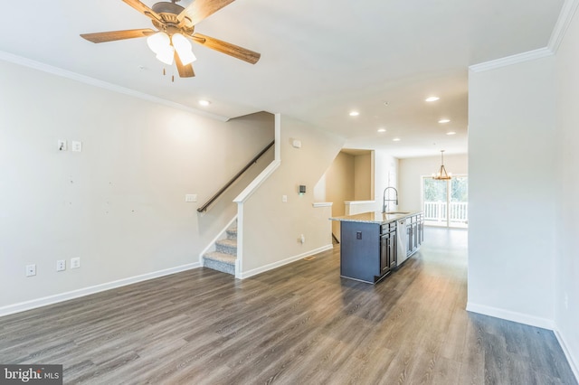 unfurnished living room with ornamental molding, dark wood-type flooring, ceiling fan, and sink