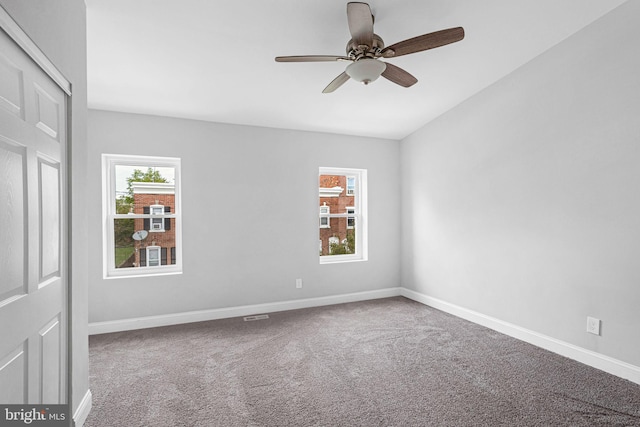 carpeted spare room featuring ceiling fan