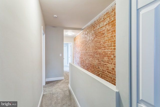 corridor with light carpet and brick wall