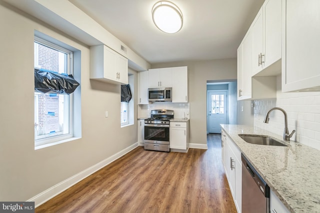 kitchen featuring a wealth of natural light, sink, white cabinetry, and stainless steel appliances