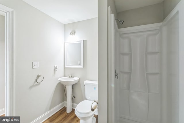 bathroom featuring toilet, walk in shower, and hardwood / wood-style flooring