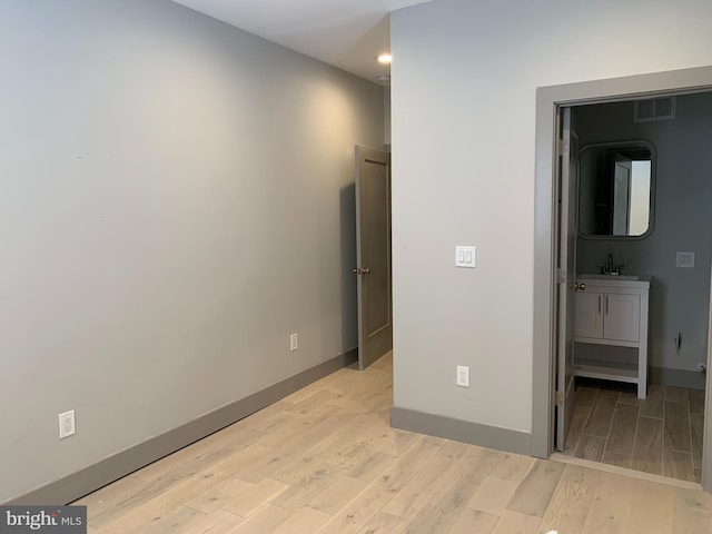 hallway featuring sink and light wood-type flooring