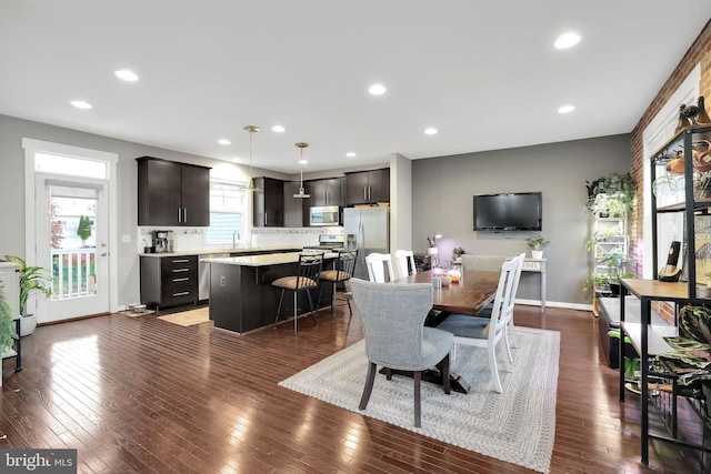 dining space with a wealth of natural light, dark hardwood / wood-style floors, and sink