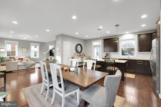 dining room with a wealth of natural light, dark hardwood / wood-style floors, and sink