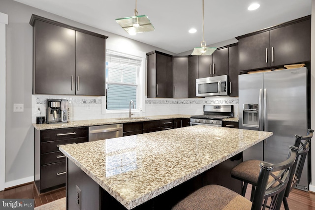 kitchen featuring dark wood-type flooring, decorative backsplash, pendant lighting, and appliances with stainless steel finishes